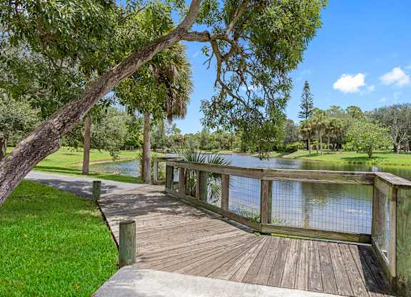 A wooden deck overlooks a calm body of water.