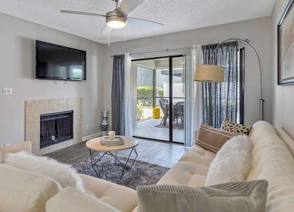 A living room with a fireplace and a television mounted on the wall.