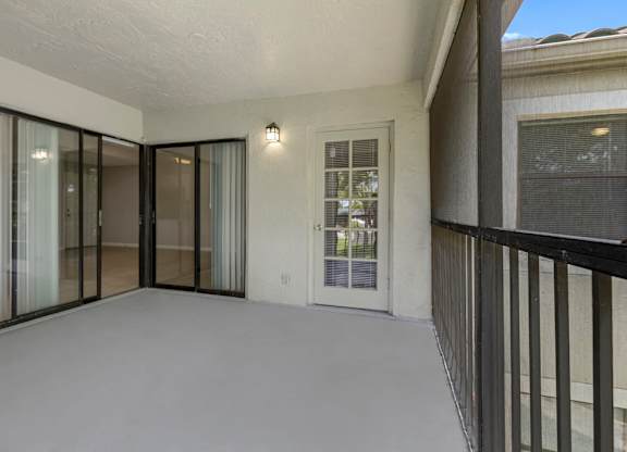 A balcony with a black railing and a glass door.
