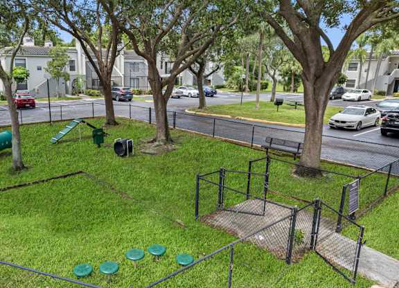A park area with a playground and green grass.