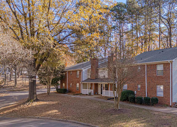 A house with a red brick exterior and a white porch.