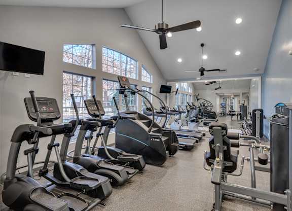 A gym with treadmills, elliptical machines, and other exercise equipment.