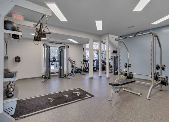 A gym with a variety of equipment including weights and exercise machines.