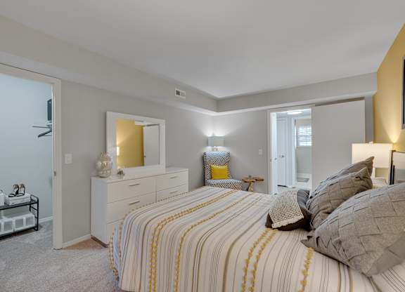 A bedroom with a bed, nightstand, and lamp.