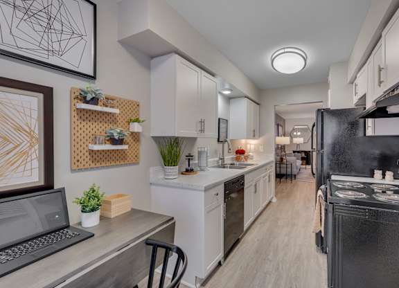 A modern kitchen with a laptop on the counter.