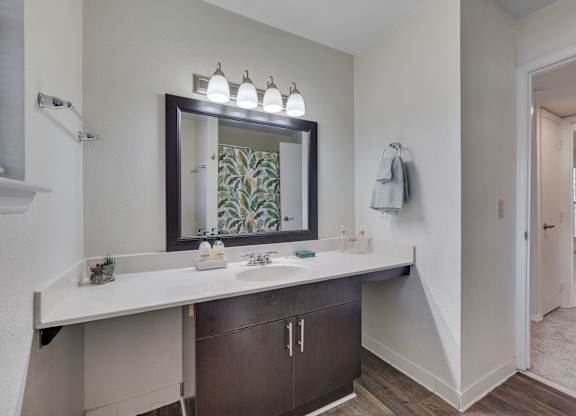 A bathroom with a large mirror and a sink.