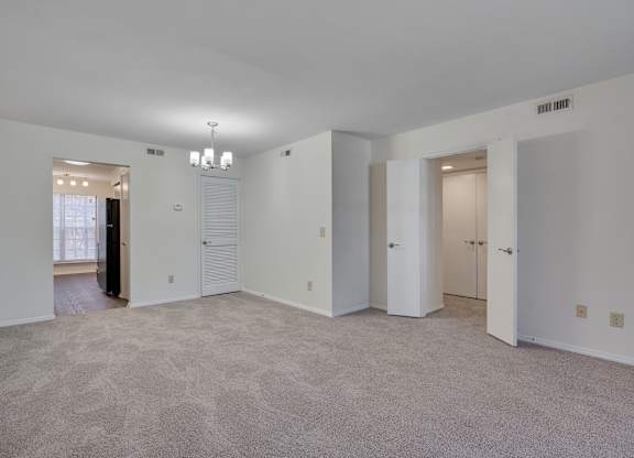 A large empty room with carpeted floor and white walls.
