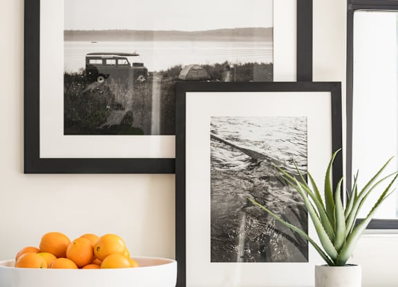 a kitchen with black and white pictures on the wall and a bowl of oranges on the counter at Bridges at Mallard Creek Apartment Homes, Charlotte