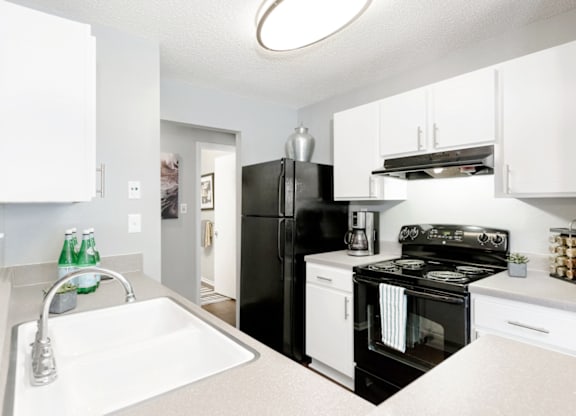 a kitchen with white cabinetry and black appliances at Bridges at Mallard Creek Apartment Homes, Charlotte, NC, 28269
