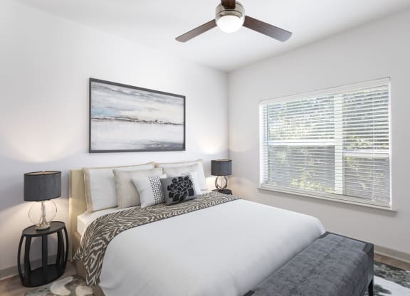 a bedroom with a large bed and a ceiling fan