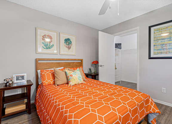 A bedroom with a closet and ceiling fan
