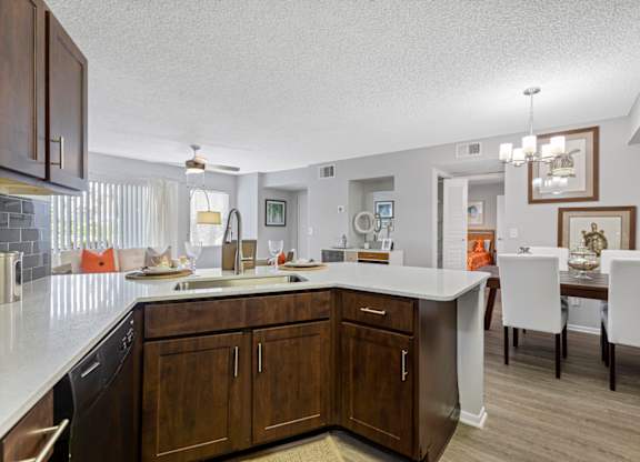 A kitchen with brown cabinets and a white counter.