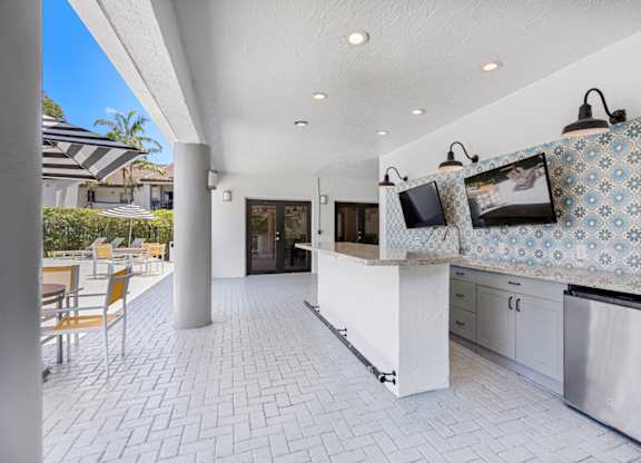 covered outdoor kitchen with TVs