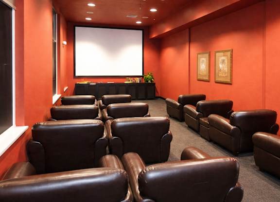 leather chairs in a media room with a screen in front of them