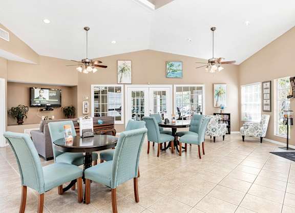 Interior of clubhouse facing a common area with chairs and tables
