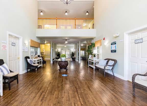 A spacious living room with a balcony and hardwood floors.