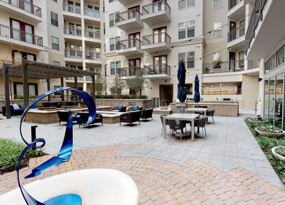 Outdoor seating areas next to sculpture and courtyard.