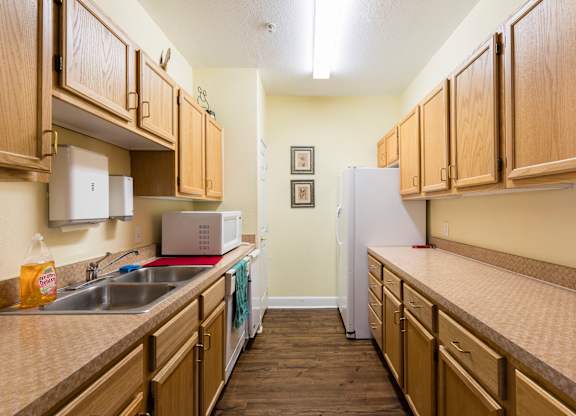 A kitchen with wooden cabinets and a white refrigerator.