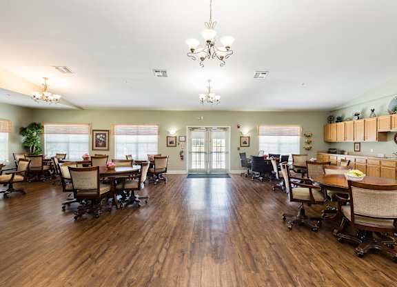 A large room with wooden floors and a chandelier hanging from the ceiling.