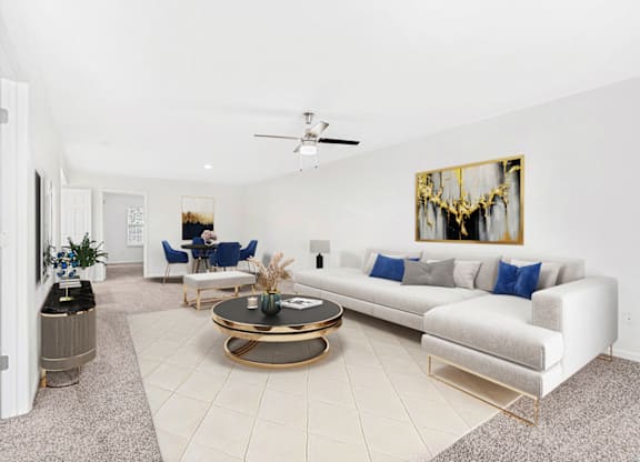 a living room with a white couch and a coffee table at Caveness Farms Apartments, Wake Forest 