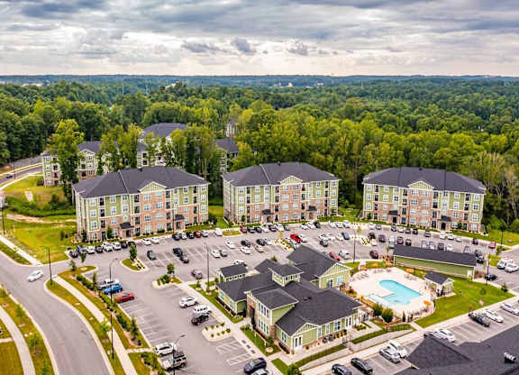 A large apartment complex with a swimming pool in the middle of a parking lot at Foxwood Apartments, North Carolina