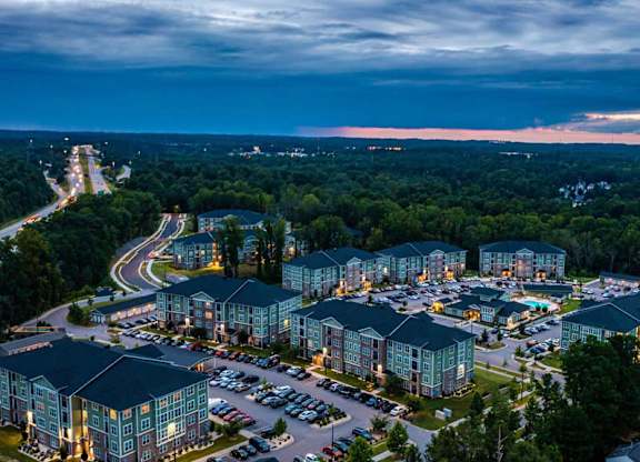 A large resort with multiple buildings and a parking lot is shown in the image at Foxwood Apartments, Raleigh-Durham, NC, 27616