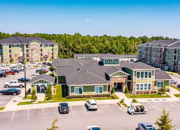 A parking lot with cars and a building in the background at Foxwood Apartments, North Carolina