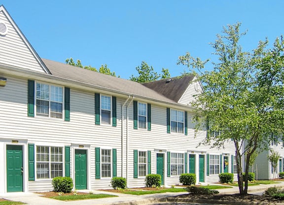 a white building with green doors and shutters