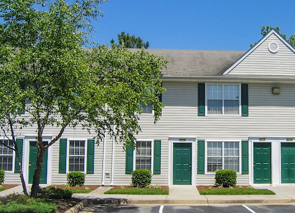 a white house with green doors and shutters