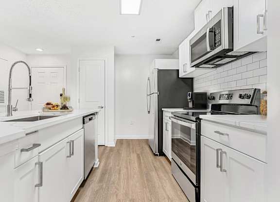 A kitchen with white cabinets and appliances. at The Grayson Apartment Homes, Charlotte, 28262
