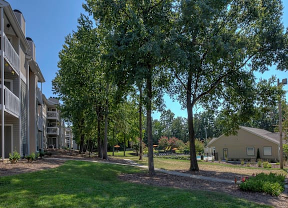 a pathway with trees and buildings on either side at Eastchester Ridge Apartments, North Carolina