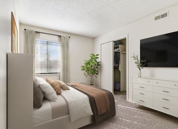 a bedroom with a bed and a dresser with a tv on top of it at Eastchester Ridge Apartments, High Point, 27262
