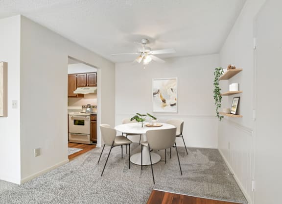 a dining area with a white table and chairs and a ceiling fan at Eastchester Ridge Apartments, High Point, North Carolina