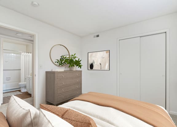 a bedroom with white walls and a bed with an orange blanket at Eastchester Ridge Apartments, North Carolina, 27262