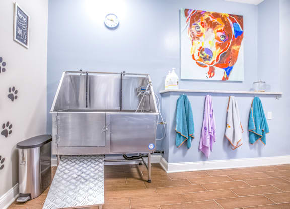 a stainless steel sink in a bathroom with a colorful painting on the wall