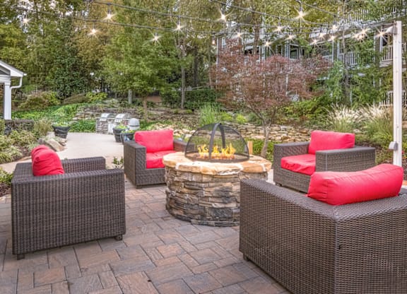 a patio with a fire pit and wicker furniture