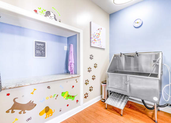 a laundry room with a tub in the corner and a shelf on the wall