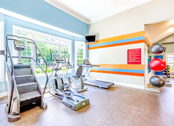 a workout room with treadmills and other exercise equipment