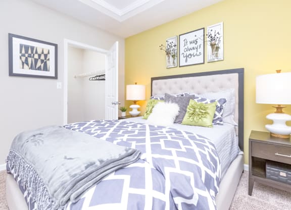 a bedroom with yellow walls and blue and white bedding