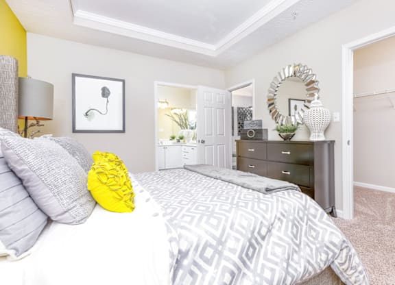 a bedroom with a large bed and a dresser with a mirror