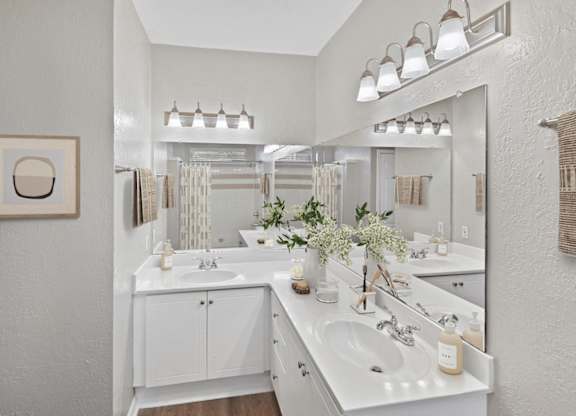 A bathroom with two sinks and a large mirror.