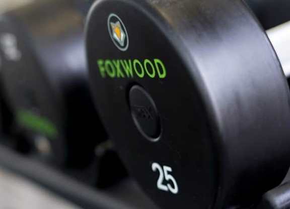 A close up of a black dumbbell with the word FOXWOOD and the number 25 printed on it at Foxwood Apartments, Raleigh-Durham, North Carolina