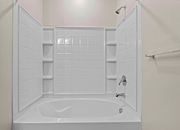A white bathroom with a white tub and white tiles at Litchford 315 Apartments, Raleigh, 27615