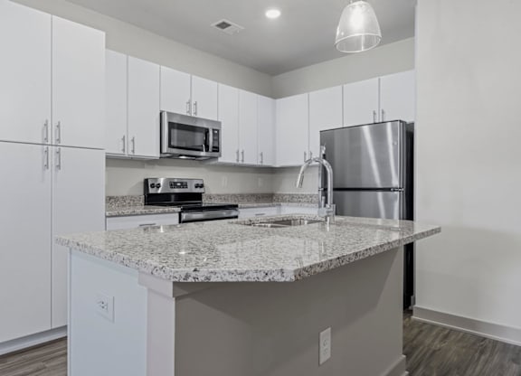 A kitchen with a granite countertop and stainless steel appliances at Litchford 315 Apartments, Raleigh, NC