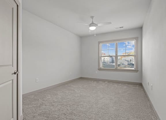 A room with a carpeted floor, a ceiling fan, and a window with blinds at Litchford 315 Apartments, Raleigh, NC, 27615