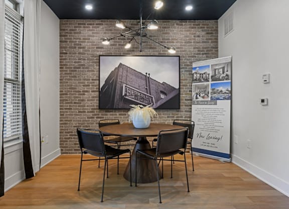 A room with a brick wall and a dining table set up at Litchford 315 Apartments, Raleigh, NC