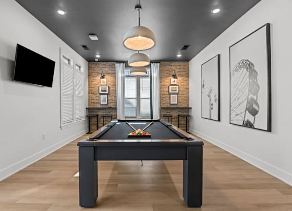 A pool table in a room with a television and framed pictures on the wall at Litchford 315 Apartments, Raleigh, NC