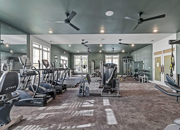 A gym with a variety of exercise equipment including treadmills, stationary bikes, and weight machines at Litchford 315 Apartments, Raleigh, NC