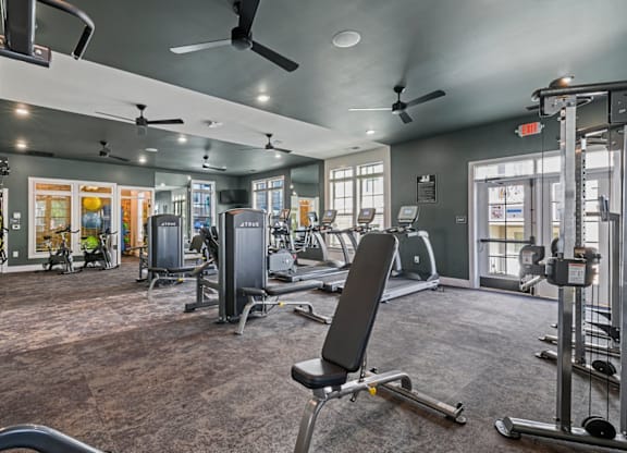 A gym with a variety of equipment including weights and cardio machines at Litchford 315 Apartments, Raleigh