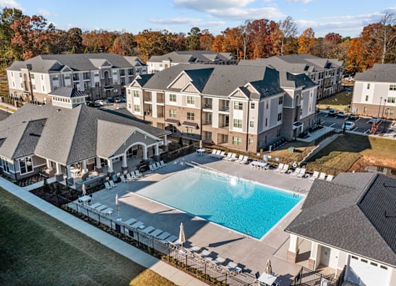 A large swimming pool is surrounded by a black fence and a white building with a black roof at Litchford 315 Apartments, Raleigh, 27615